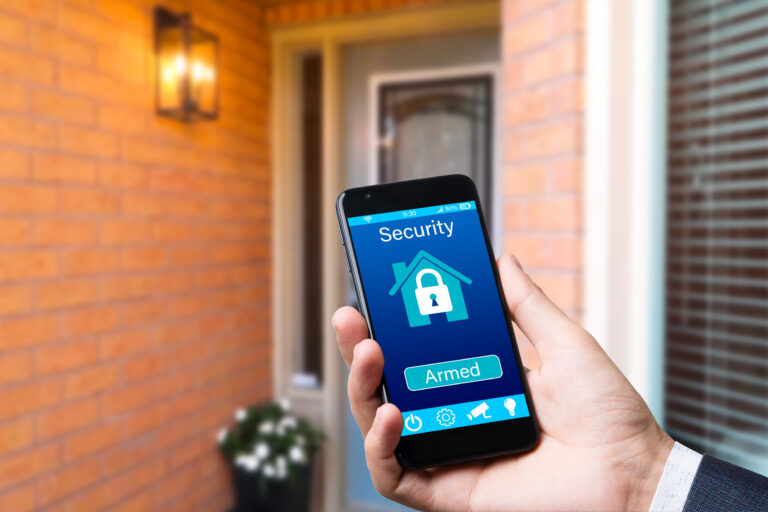 man controls smart home devices using app for mobile phone on background of the front door. concept of digitalization. a mockup with hand holding phone